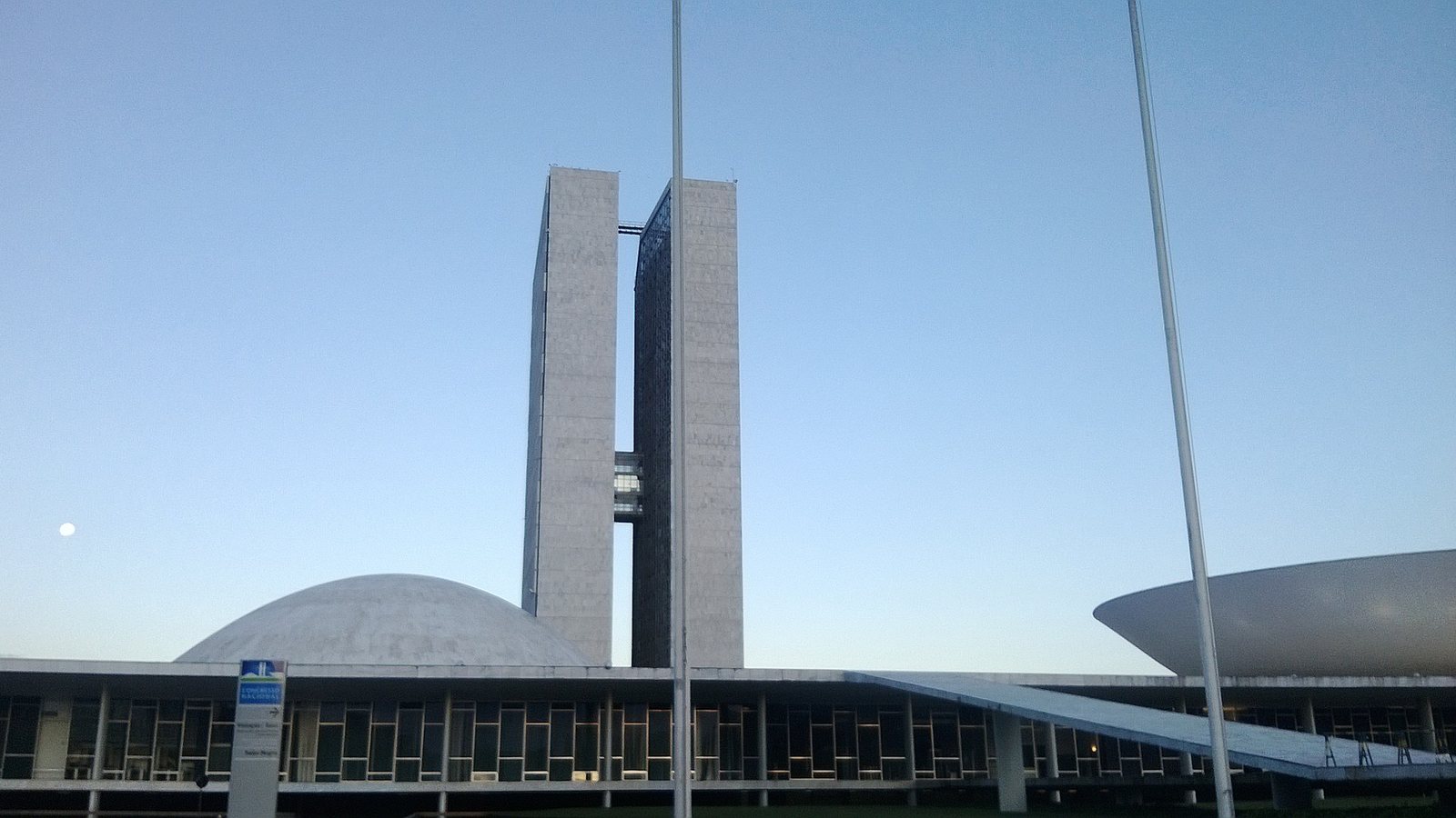The twin towers and domes of the National Congress in Brasília under a clear pale blue sky