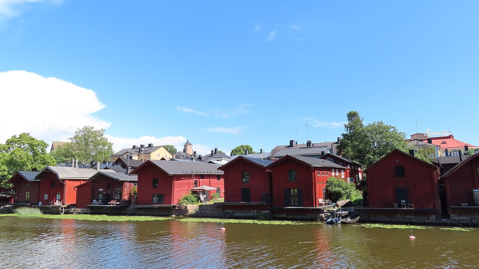 Red wooden riverside warehouses in the old town of Porvoo, Finland, on a summer day