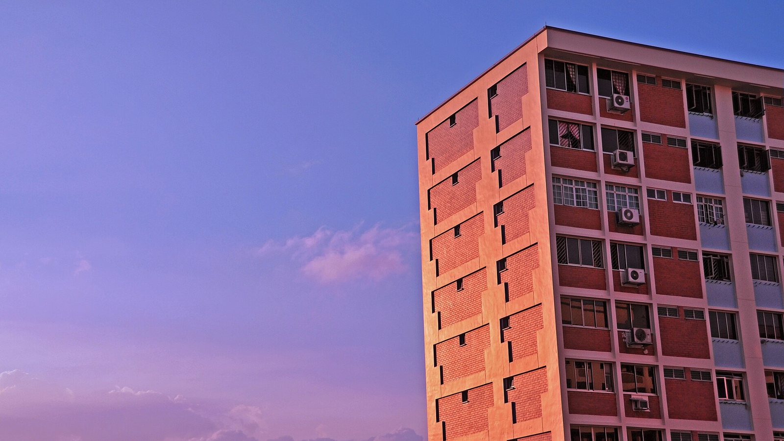 A block of HDB flats in Singapore lit by low sun