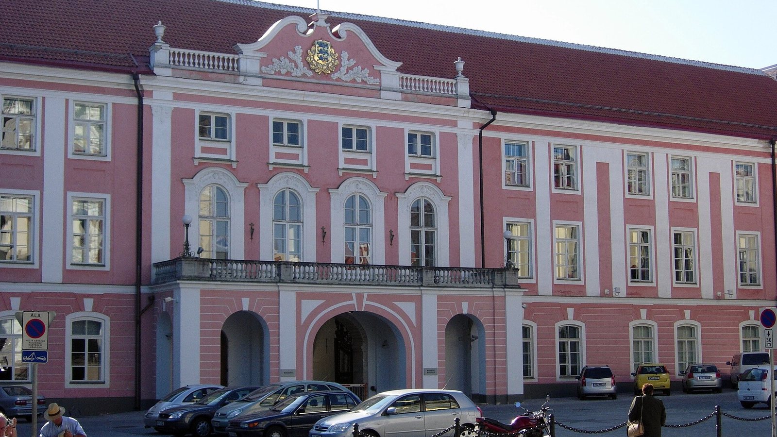 The pink baroque facade of Toompea Castle in Tallinn, seat of the Estonian Parliament, with the national coat of arms above the balcony