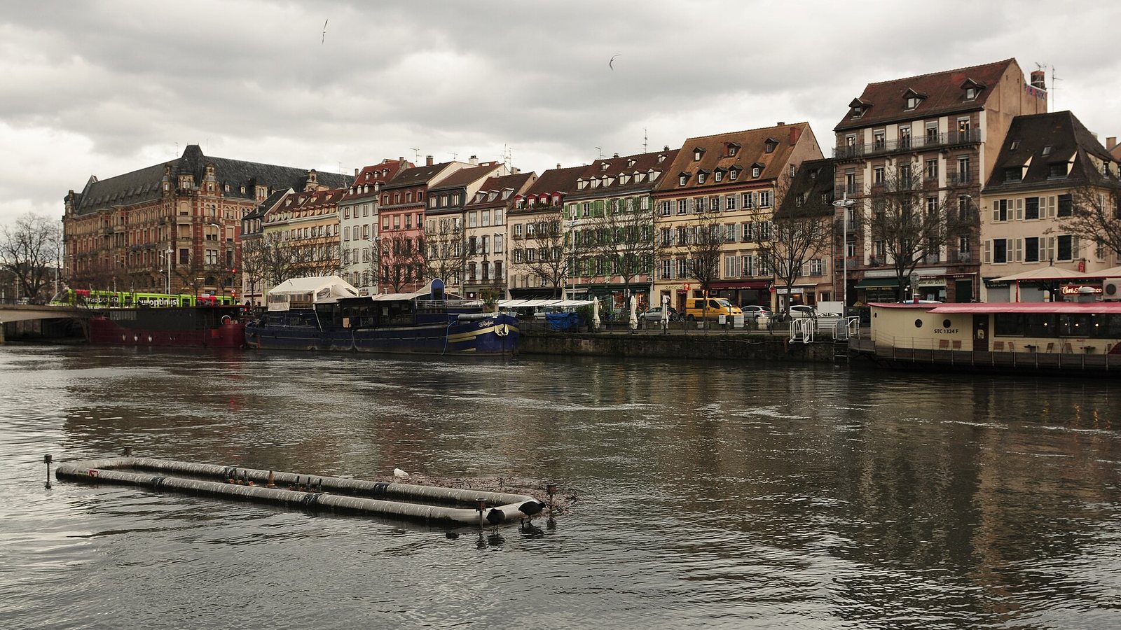 Historic townhouses and moored boats along the quays of the Ill river in Strasbourg