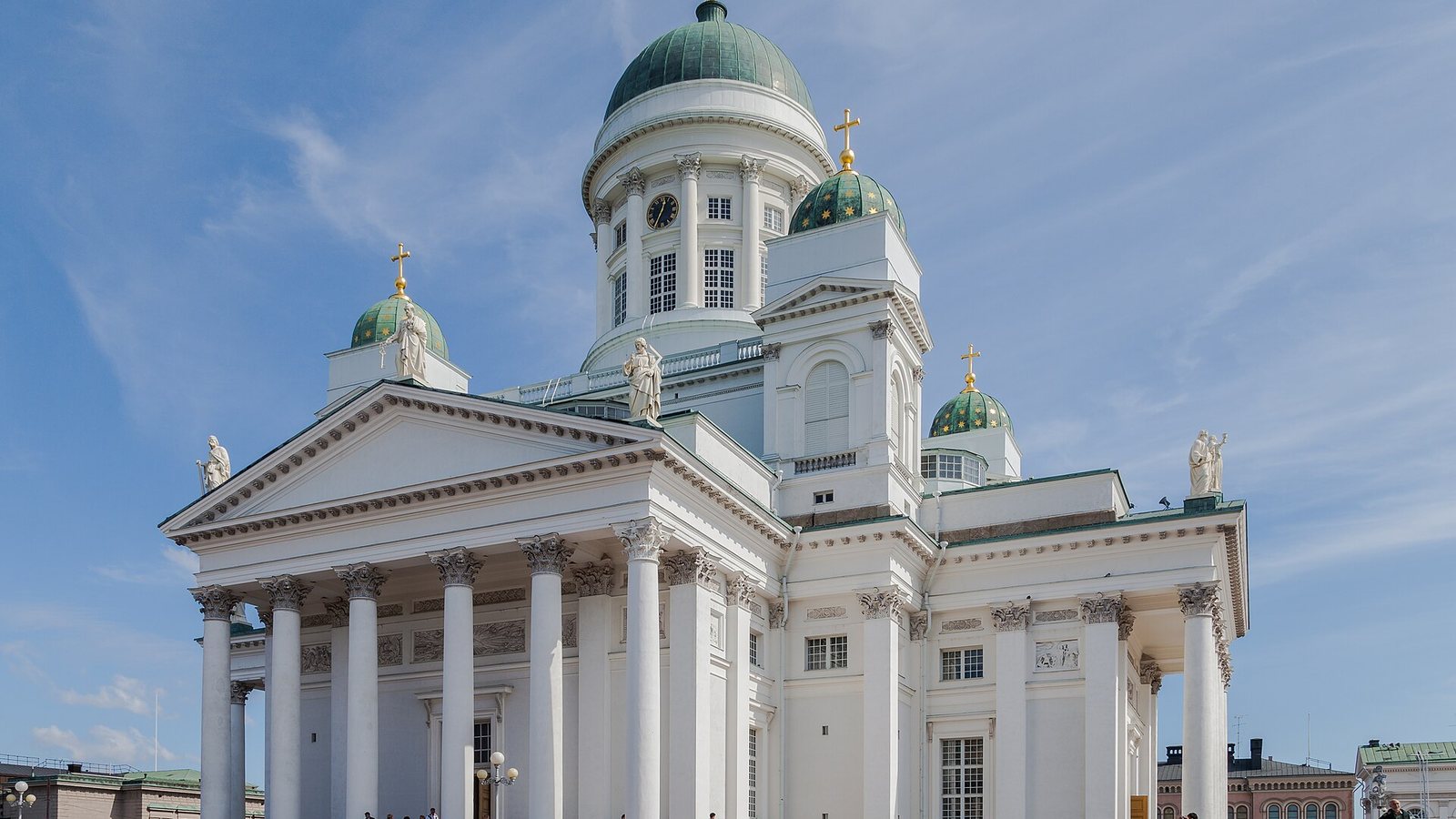 Helsinki Cathedral with its white columns and green domes against a blue sky