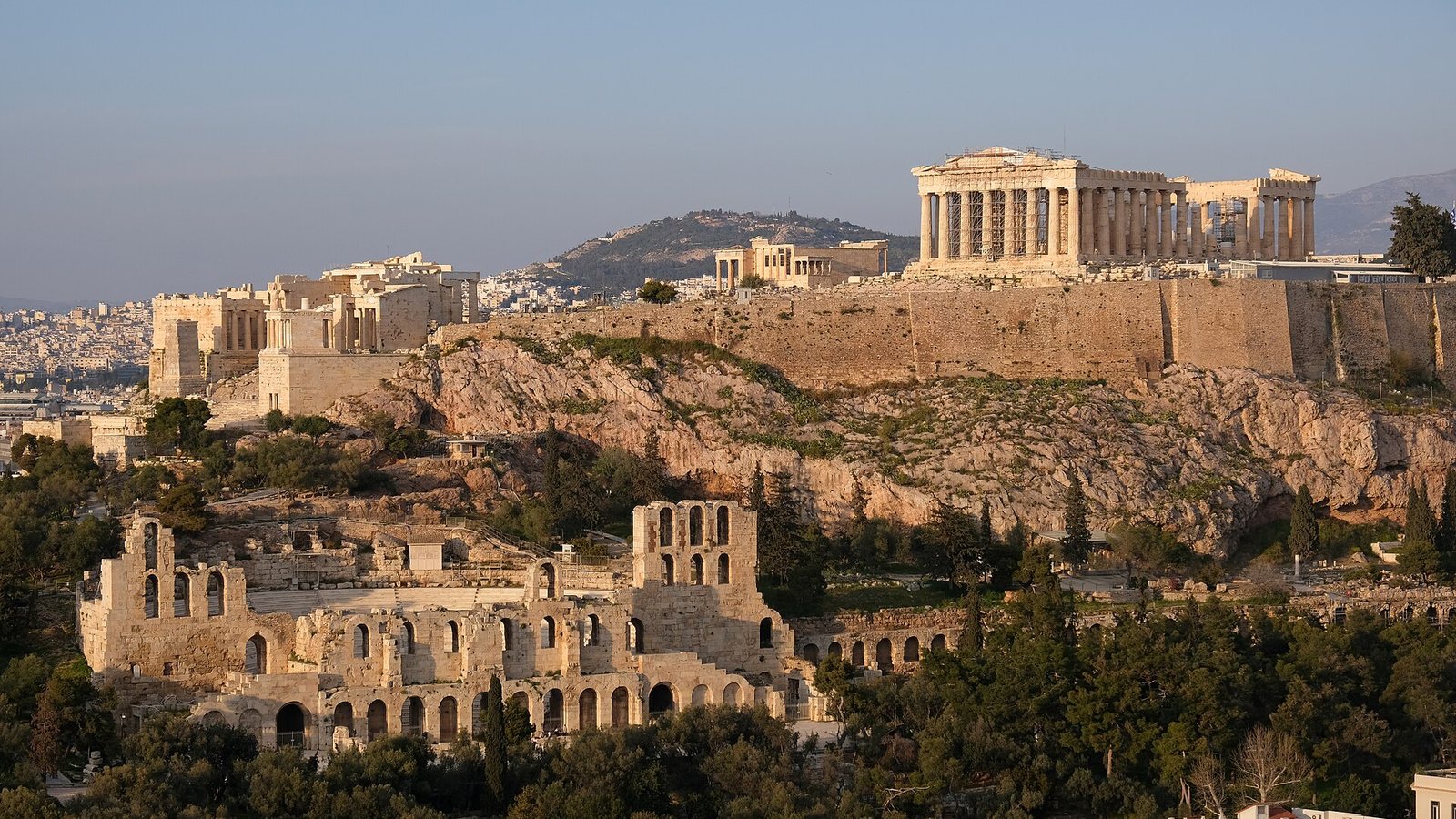 The Acropolis of Athens with the Parthenon above the rock and the Odeon of Herodes Atticus below, lit by low sun