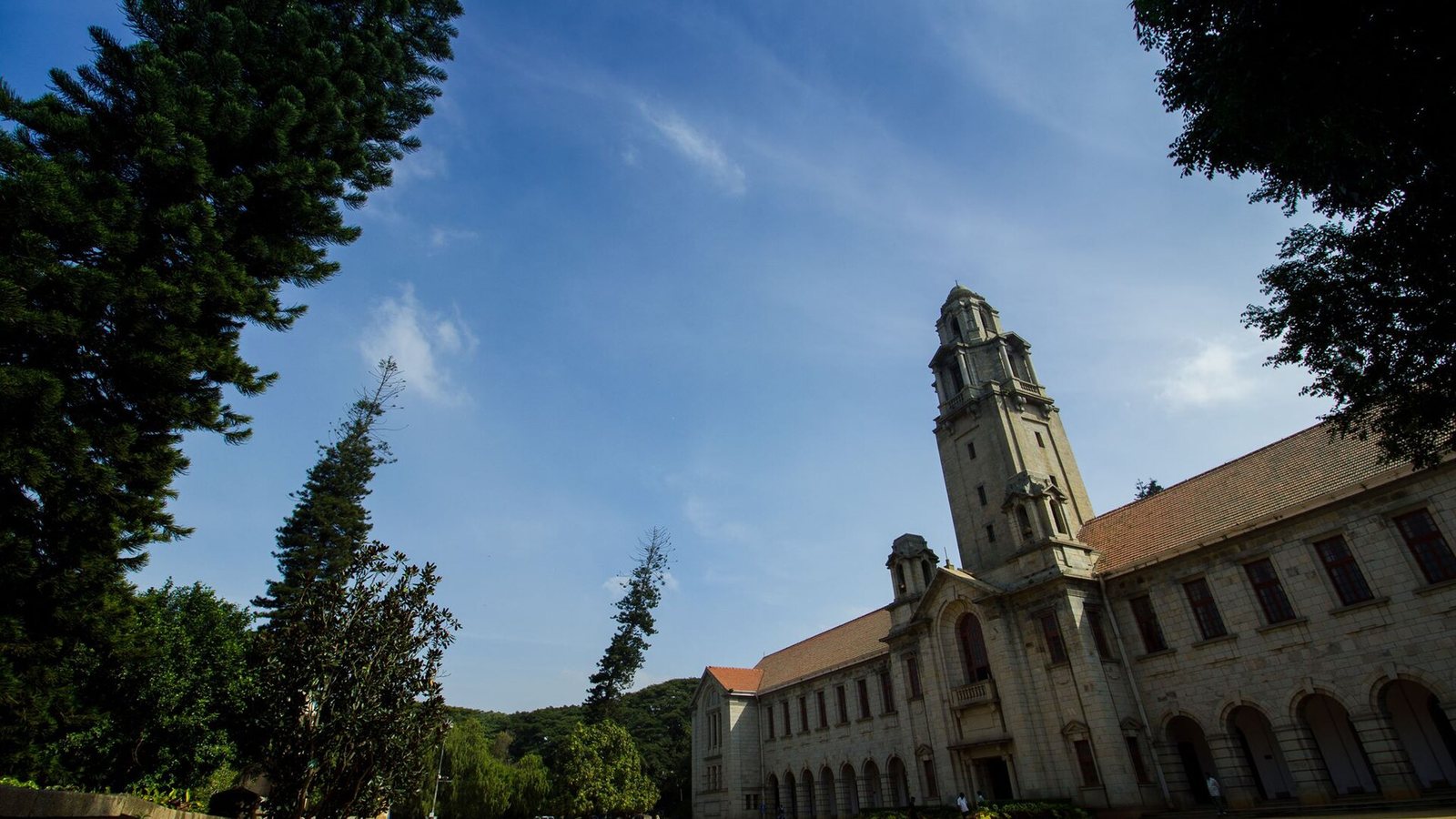 Main building and clock tower of the Indian Institute of Science in Bengaluru under a blue sky