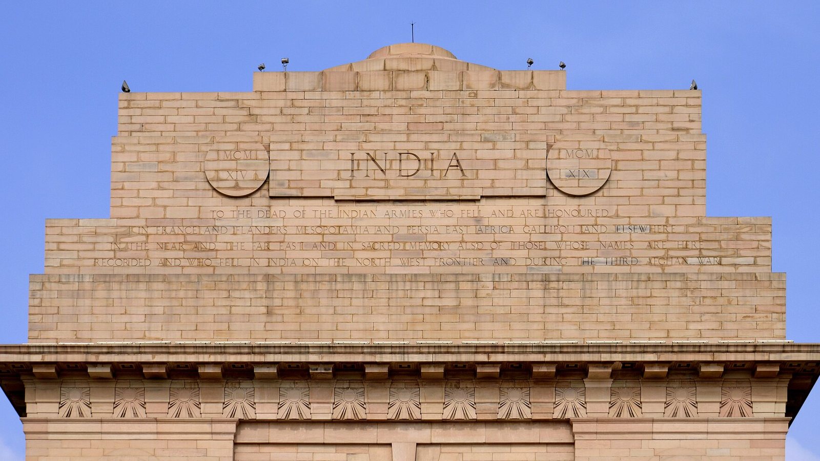 Upper section of India Gate in New Delhi with the word India carved in sandstone