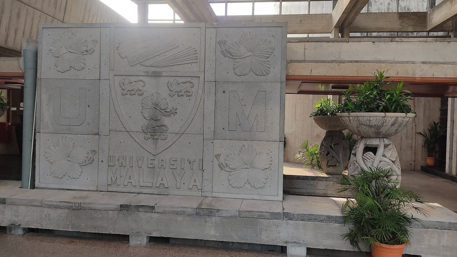 Concrete relief wall with the crest and name of Universiti Malaya at the Dewan Tunku Canselor in Kuala Lumpur