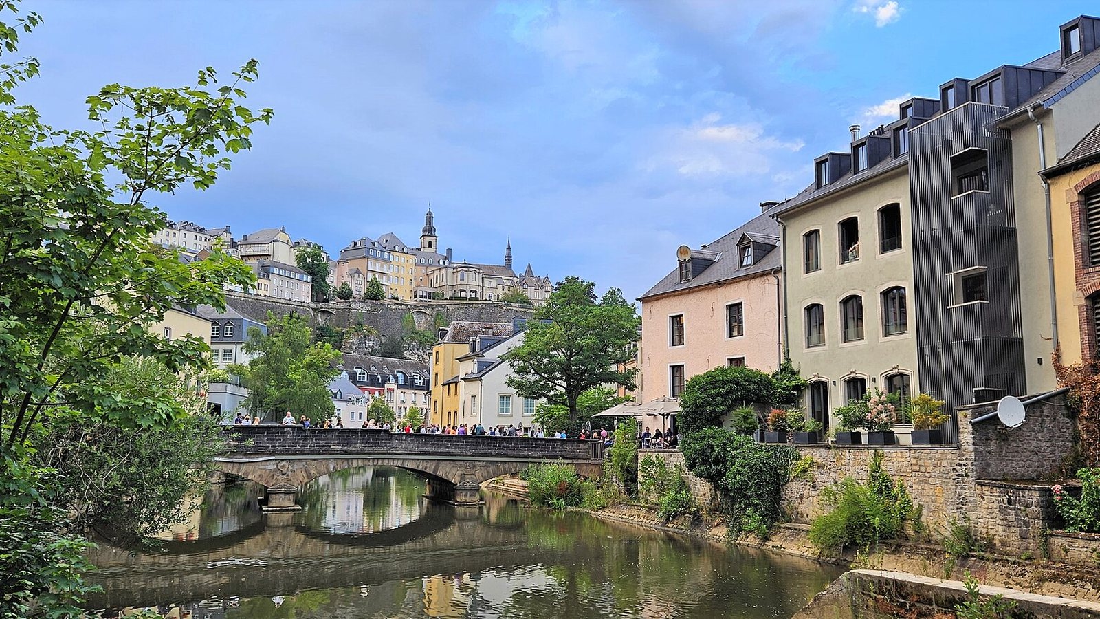 Houses along the river Alzette in the Grund quarter of Luxembourg City, with a stone bridge and the upper town on the cliff behind