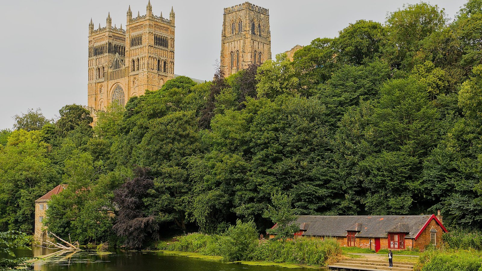 Durham Cathedral rising above trees on the bank of the River Wear, England