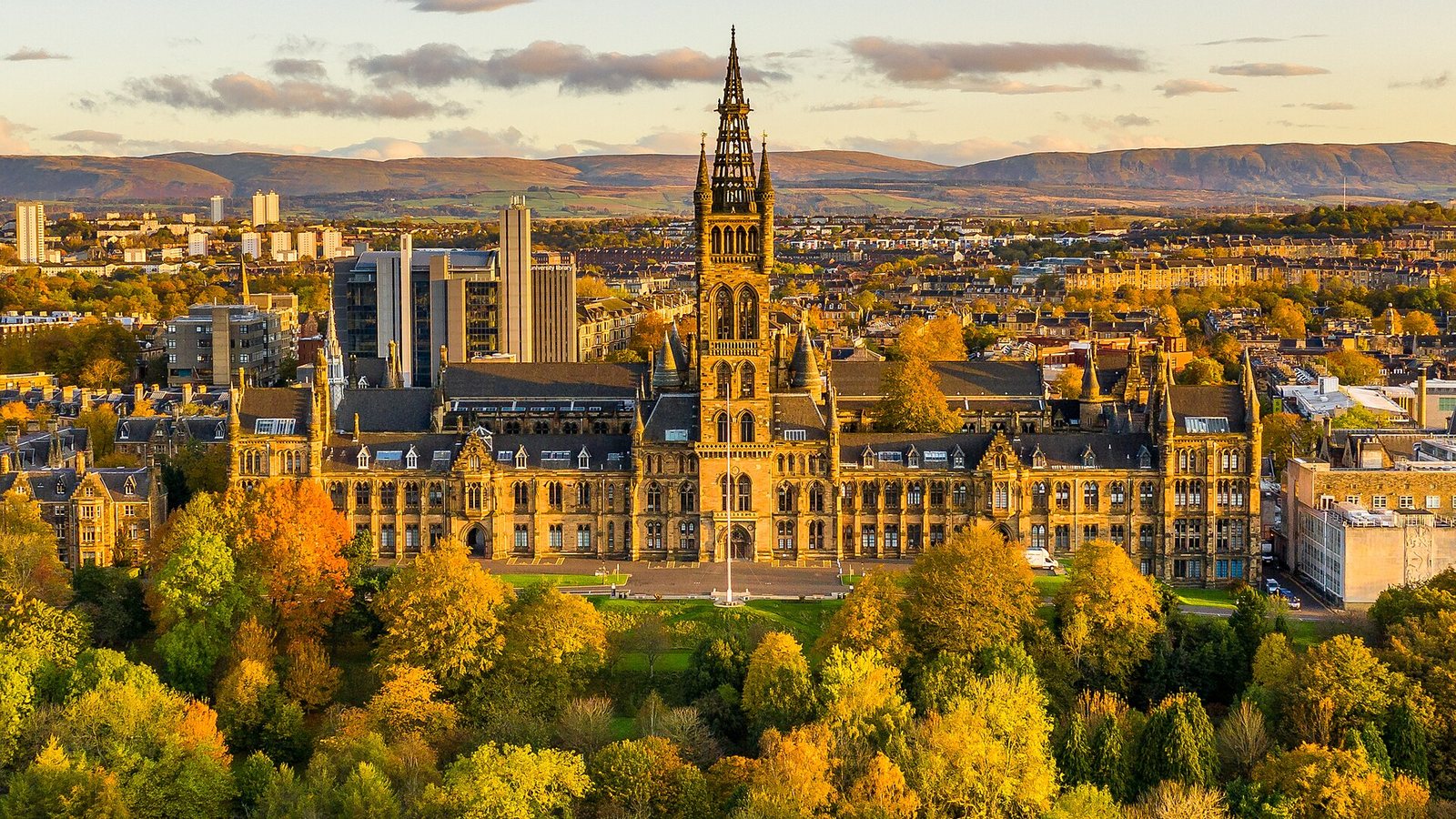 Aerial view of the University of Glasgow main building surrounded by autumn trees