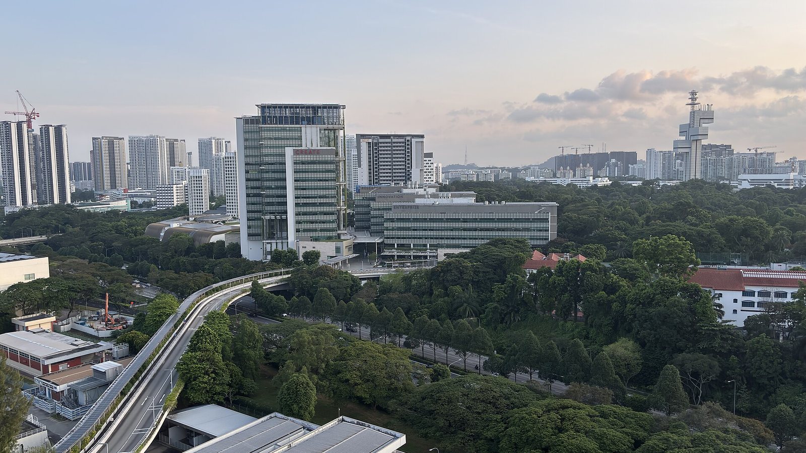 Aerial view of the CREATE Tower and University Town at the National University of Singapore surrounded by trees