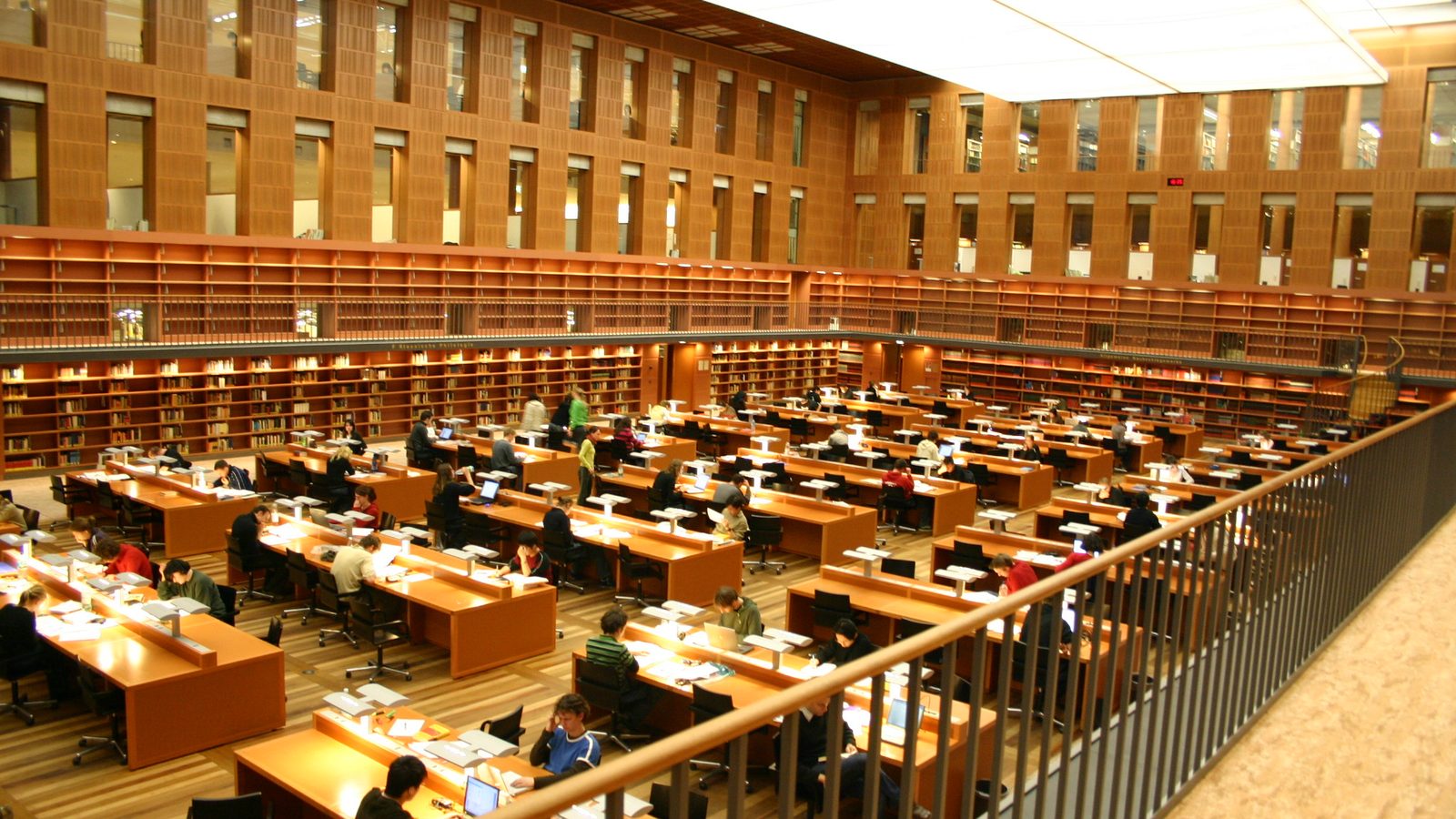 Students working at long desks in the reading room of the Saxon State and University Library (SLUB) in Dresden