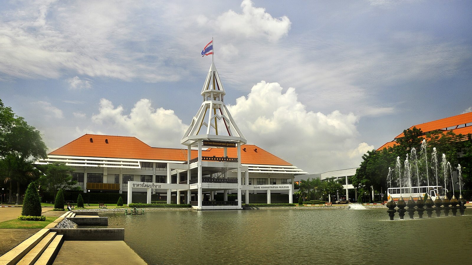 The Dome Administration Building at Thammasat University's Rangsit campus, with its white tower, orange roofs and a fountain pond