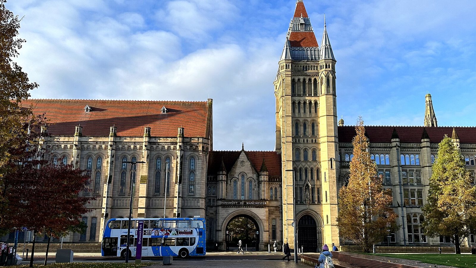 The Queen's Arch and tower of the University of Manchester on a sunny autumn day