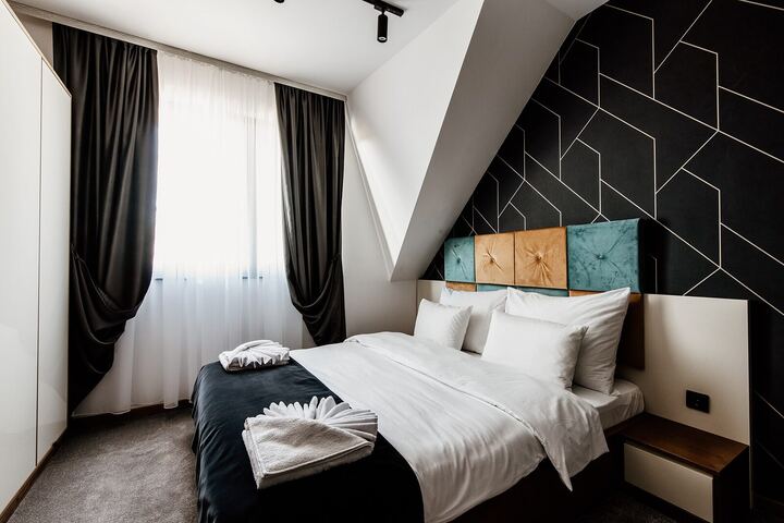 Studio bedroom with black geometric feature wall